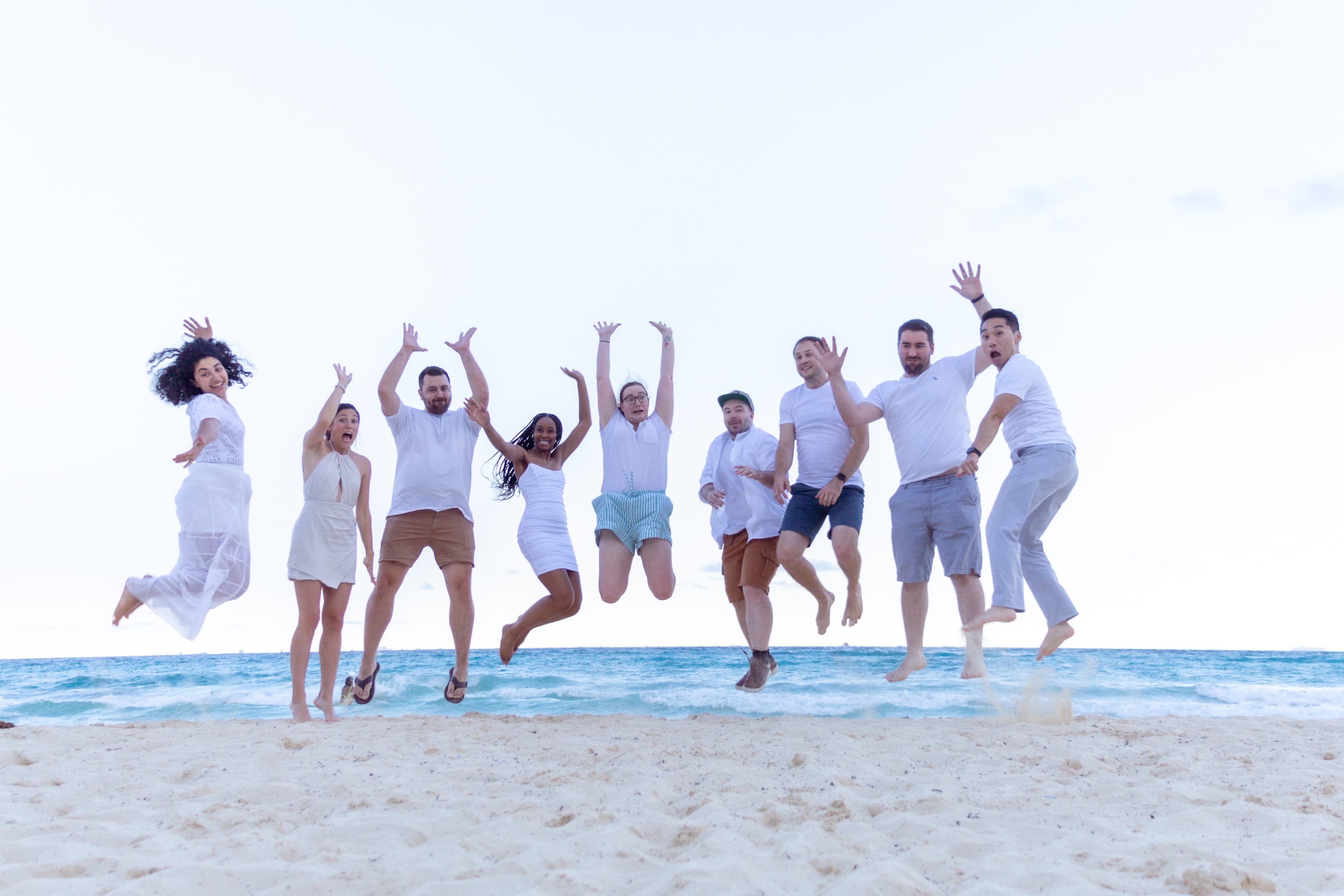 The 42 team jumping together on a beach